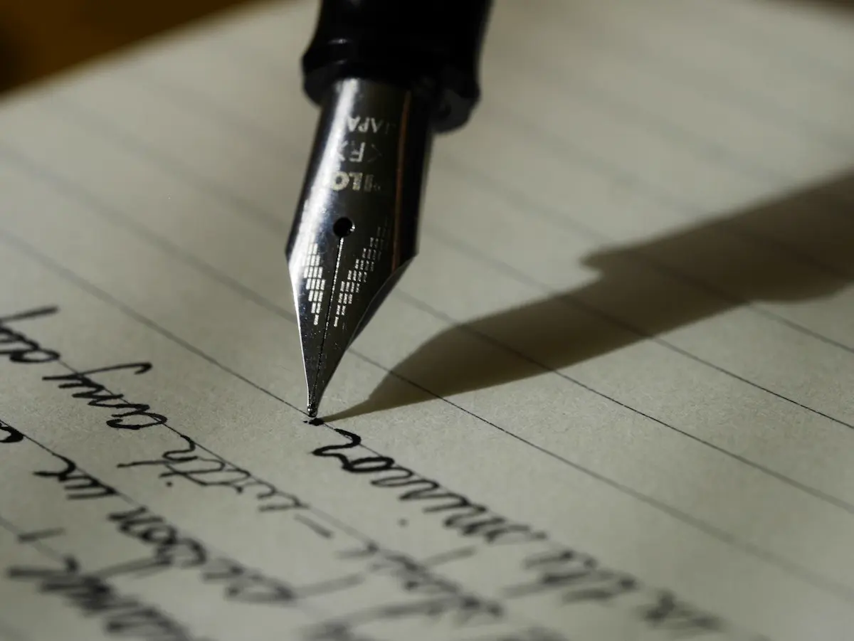 Fountain pen resting on a blank page — writing your story