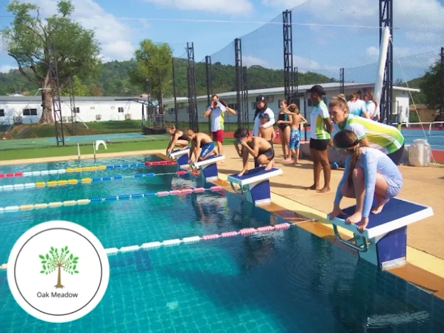 Swimming lesson with young students at the starting blocks